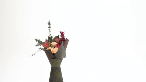 Beautiful bouquet with flowers in a green vintage vase revolves around its axis Stock Footage
