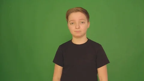 A beautiful boy shows different emotions on a green background. Camera in 4K. Stock-Footage 84633587