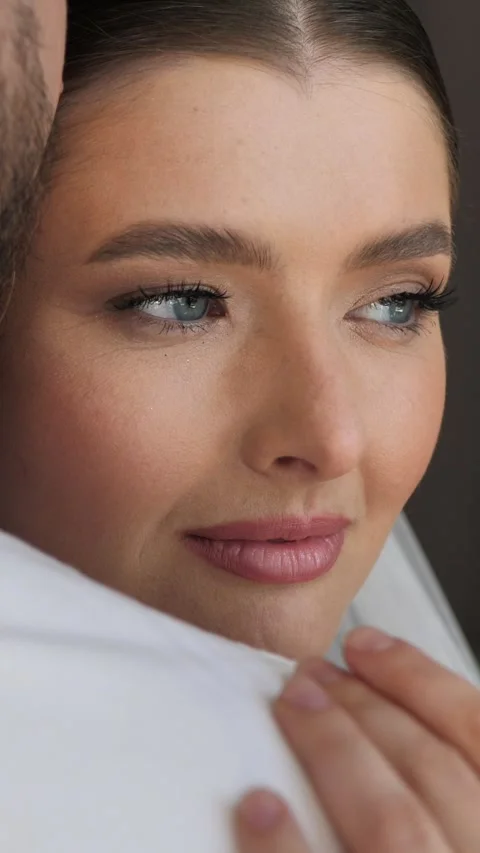 Beautiful bride looking away, leaning on the groom's shoulder, close-up. Stock Footage 340431716
