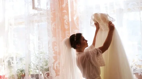 Beautiful bride looking on her wedding dress before ceremony Stock Footage 73781740