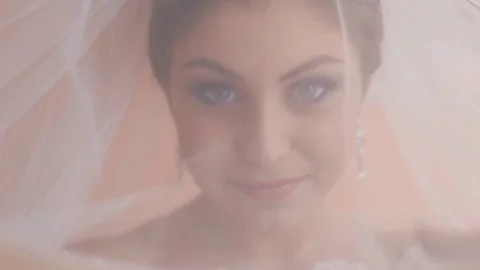 Beautiful bride looking through the veil on the camera. Woman opening bridal Stock Footage 73781798