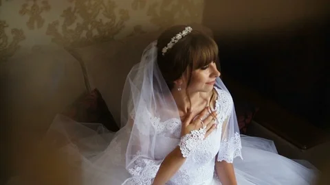 Beautiful bride posing near the window holding bouquet. Bride's morning. Video stock 95560567