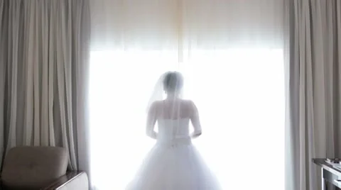 Beautiful bride posing at window in hotel room Stock Footage 56844549