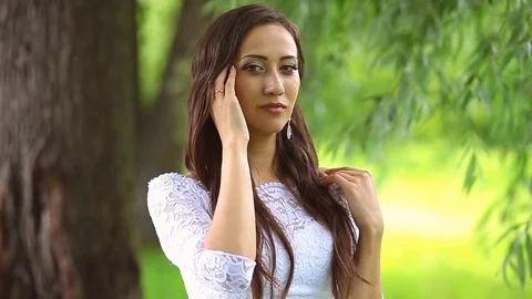 Beautiful bride smiling at camera in the park on a sunny day Stock Footage