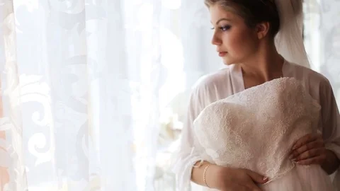 Beautiful bride trying on laces wedding dress before wedding ceremony and Stock Footage 73781744