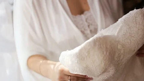 Beautiful bride trying on laces wedding dress before wedding ceremony Stock Footage 73781749
