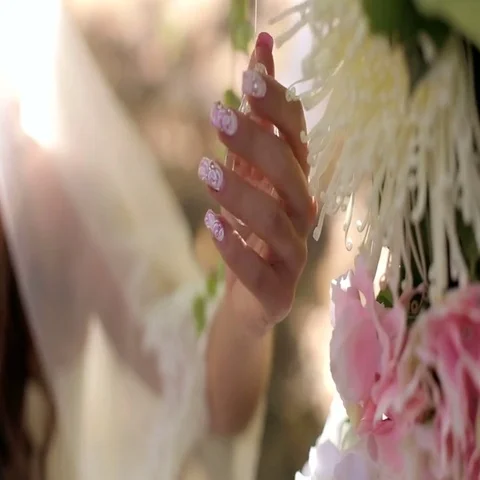 Beautiful bride's hand stroking the flowers. Crystals in the wedding decor. Stock Footage 69427451