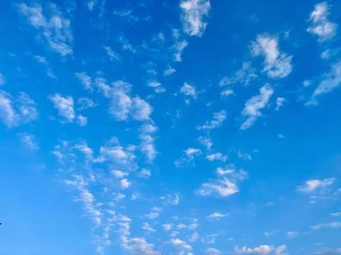 Beautiful bright blue sky filled with soft white clouds on a clear sunny day Stock-Fotos