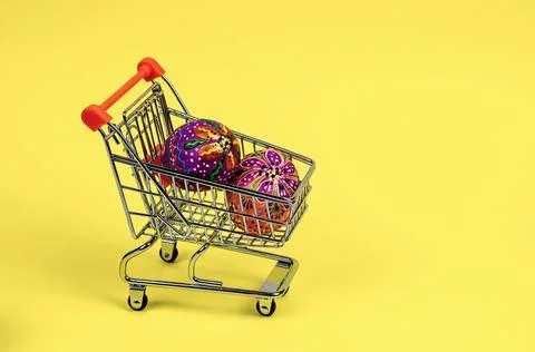 Beautiful bright hand-painted Easter eggs in a supermarket trolley Stock Photos