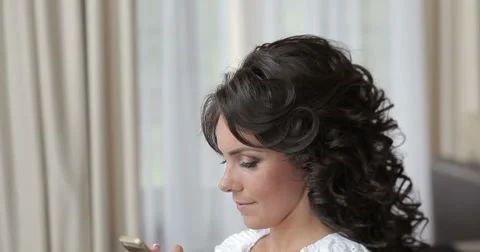Beautiful brunette bride preparing and using cell phone Stock Footage 62655336