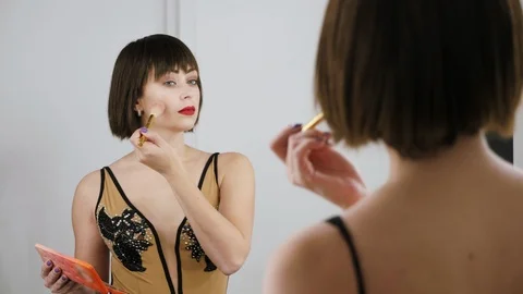 Beautiful brunette girl does makeup near mirror Stock Footage 97745846