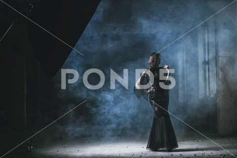 A beautiful brunette lady in ruins. Evening dress. Fashion, beauty. Stock Photos