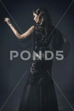 A beautiful brunette lady in ruins. Evening dress. Fashion, beauty. Stock Photos
