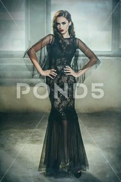 A beautiful brunette lady in ruins. Evening dress. Fashion, beauty. Stock Photos