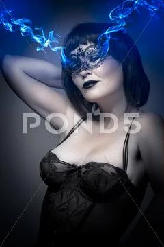 Beautiful brunette in lingerie, blue smoke coming out of the eyes Stock Photos