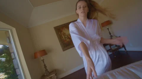 Beautiful brunette model moves through a room and lies on a sofa in slow motion 스톡 동영상 45817580