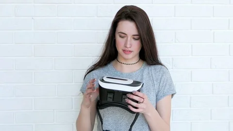 Beautiful brunette puts on virtual reality glasses 스톡 동영상 74468016