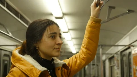 Beautiful brunette rides in the subway while standing. Smile on his face. Close Stock Footage 128194700