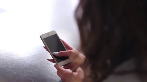 Beautiful brunette using cell phone and texting Stock Footage 74516272