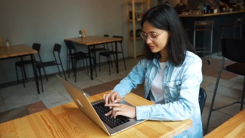 Beautiful brunette using laptop in cafe Stock Footage 112409720
