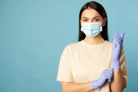 Beautiful brunette wearing protective gloves during quarantine Stock Photos