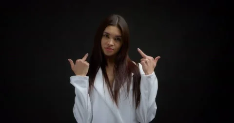 Beautiful brunette in a white jacket shows fuck you, two middle finger. Stock Footage 170196909