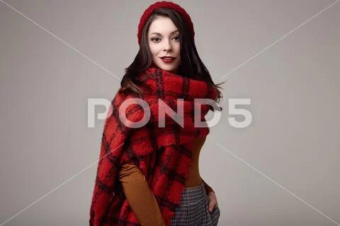 Beautiful brunette woman in sweater and red hat with big knitted scarf Stock Photos