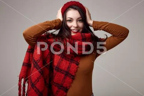 Beautiful brunette woman in sweater and red hat with big knitted scarf Stock Photos