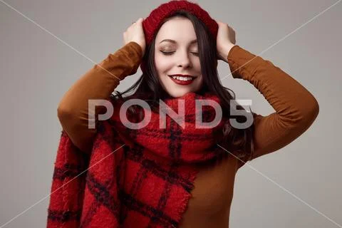 Beautiful brunette woman in sweater and red hat with big knitted scarf Stock Photos