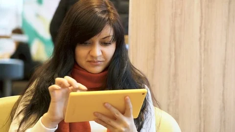 Beautiful brunette writes a message on a tablet. Stock Footage 83761936