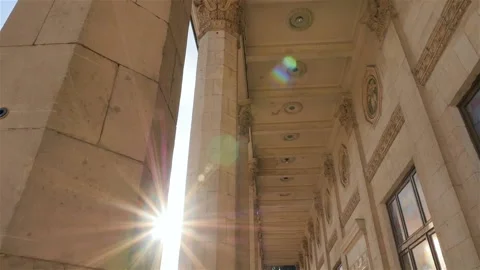 Beautiful building with columns. Bright sun shines into the camera. Slow motion Stock Footage 103419787