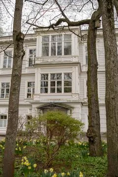 Beautiful Building With Large Windows Surrounded by Trees and Blooming Flowers Stock Photos