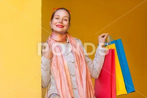 The beautiful bun haired woman in casual clothing with shopping bags, looking Stock Photos