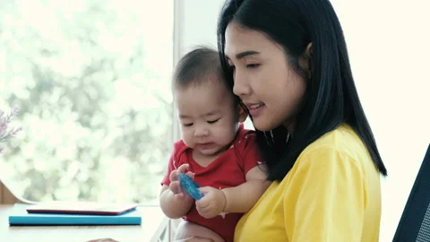 Beautiful business asian mom is using a laptop and smiling  스톡 동영상 139658695