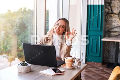 Beautiful business woman sitting in cafe and working. Stock Photos