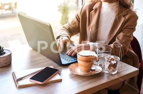 Beautiful business woman sitting in cafe and working. Stock Photos