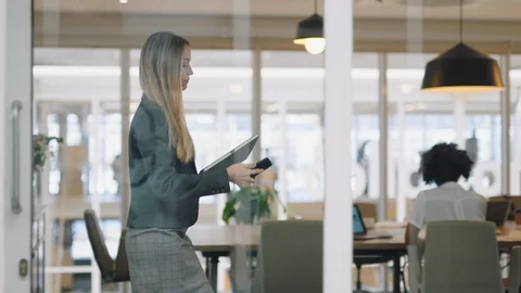 Beautiful business woman using smartphone walking through office texting sending Stock Footage