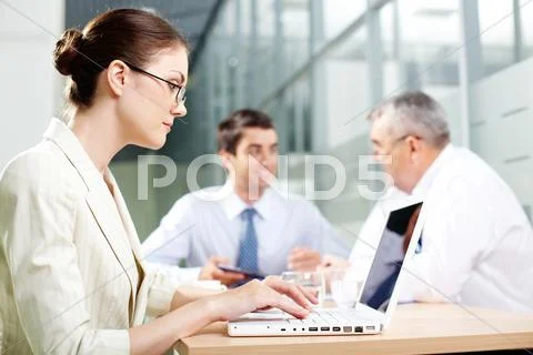 A beautiful businesswoman typing in working environment Stock Photos