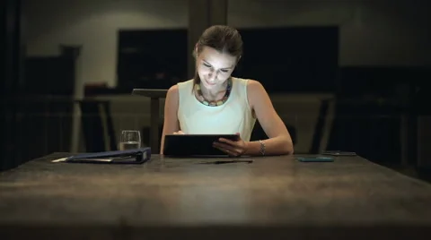 Beautiful businesswoman working on tablet computer in the office at night HD Stock Footage