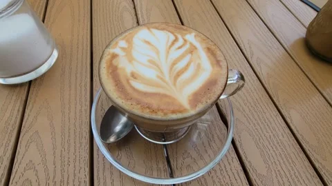 Beautiful cafe latte drink with a leaf art on top. Stock Footage 320484689