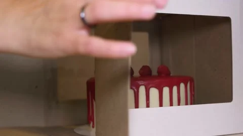 A beautiful cake is given from a cardboard box. Carefully remove the confection Stock Footage 154875811