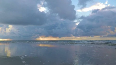 Beautiful calm ocean beach waves at sunrise sunset wash around camera Stock Footage 91231280