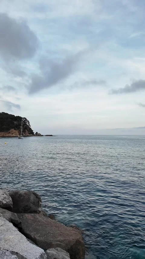 Beautiful calm sea view with a mountain, cloudy sky, sunset, vertical background Stock Footage 276736053