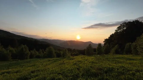 Beautiful calm sunset above forest and mountains in background Stock Footage 333561709
