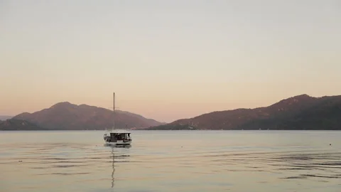 Beautiful calm sunset with only one yacht on the sea. Boat navigating in Marmari Stock-Footage 154336242