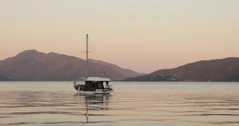 Beautiful calm sunset with only one yacht on the sea. Boat navigating in Marmari Stock Footage 154336255