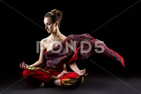 Beautiful calm woman meditates in lotus position Stock Photos