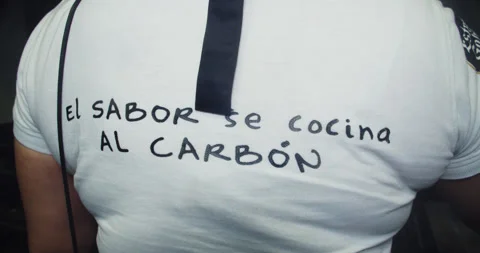 Beautiful on-camera shot of the back of a young Latina chef cooking a Stock Footage 282781337