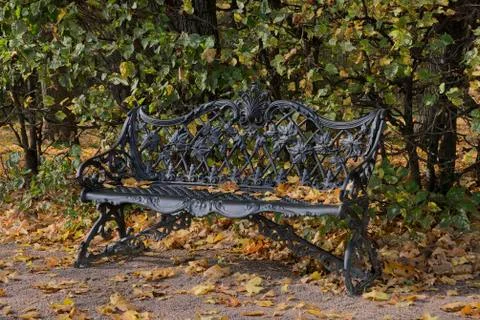 Beautiful cast bench in the autumn Park. Stock Photos