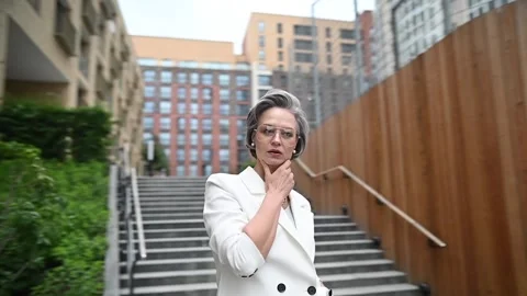 Beautiful caucasian elderly gray-haired business woman takes off her glasses Video stock 255759787